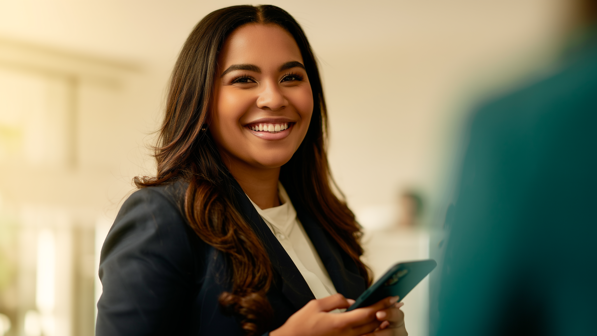 Funcionária de pequena empresa sorrindo enquanto registra o ponto pelo celular